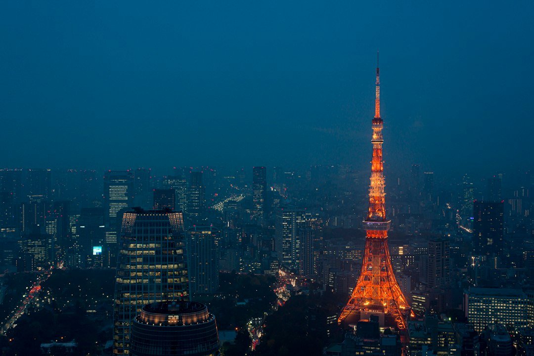 Tokyo Tower glowing above the city skyline, representing the Bank of Japan and the Japanese yen